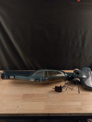 un aspirateur posé sur une table en bois