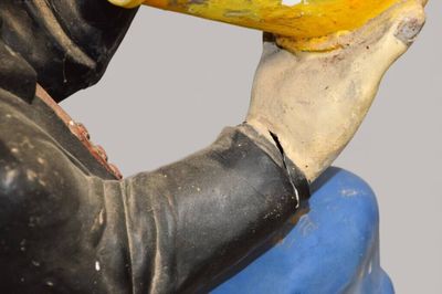 une statue représentant un homme tenant une banane à la main