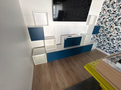 une photo d'un salon avec une télévision et un banc jaune