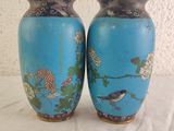 pair of blue vases with birds and flowers on them on a white surface