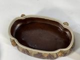 a brown and white bowl sitting on a white table