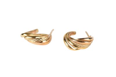a pair of gold earrings with wavy design on them
