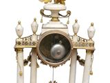 a white and gold clock sitting on top of a table