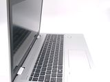 a silver laptop computer sitting on a white surface