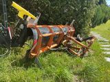 a tractor that is sitting in the grass with a plow attached to it