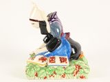 a figurine of a woman reading a book