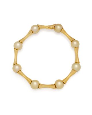 un bracelet en or orné de perles sur fond blanc
