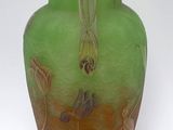 a green and orange vase sitting on a white surface