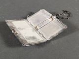 a small silver case with a mirror inside of it