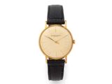 an 18k yellow gold wrist watch with black leather strap