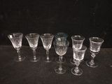 several empty wine glasses are lined up on a black surface