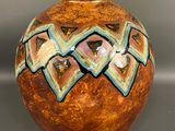 a brown vase with a blue and green design on it
