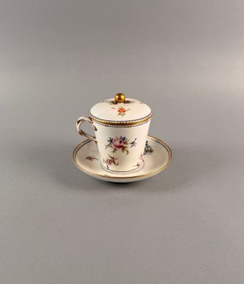 tasse à thé avec soucoupe, posée sur une autre soucoupe, sur fond gris