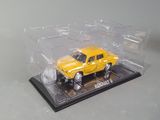 a yellow toy truck in a clear box on a table