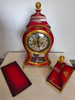 une horloge rouge et dorée posée sur une table