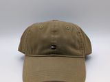 Le chapeau est de couleur beige et comporte un petit écusson sur le devant.