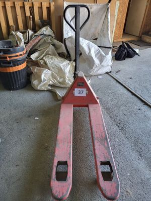 a fork lifter sitting on the floor in a garage