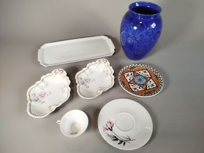 un vase bleu, une assiette, un bol et un plateau posés sur une table