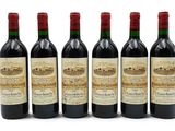 six bouteilles de vin sont alignées sur une surface blanche