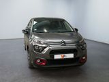 the front of a grey car in a room with a white wall