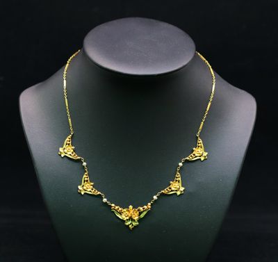 un collier en or sur un mannequin, sur fond noir