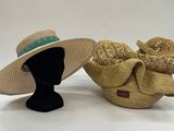 pair of straw hats with bows on display on white background