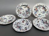 four plates with different designs on them sitting on a table
