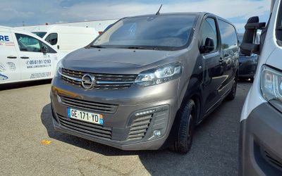 a silver van parked in a parking lot next to a white van