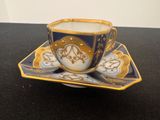 une tasse et une soucoupe posées sur une table, sur fond noir