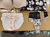 a box full of underwear and bras sitting on the floor
