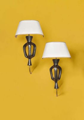 trois lampes accrochées à un mur jaune, équipées d'un abat-jour blanc