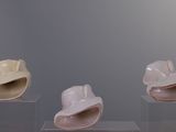 three hats that are on display in a glass case