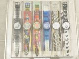 many different watches in a clear box on display