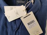 a close up of a blue shirt with a tag on it