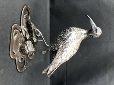 un oiseau accroché au mur à côté d'une porte