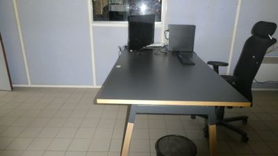 a desk with a chair and a computer on it
