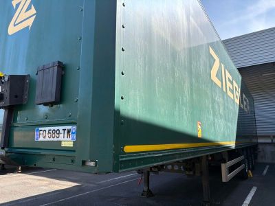 un grand camion vert garé sur un parking
