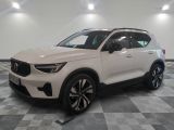 a white volvo suv parked on a checkered floor in a showroom