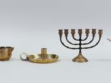 several different types of brass objects including a candelab, a teapot, a candelab, and a candelab