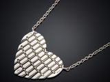 a silver heart shaped pendant with a chain on a black background