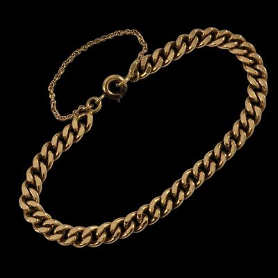 un bracelet à chaîne en or avec un fermoir sur fond noir