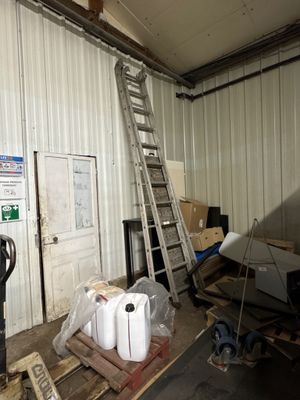 une photo d'une pièce avec une échelle et de nombreuses boîtes