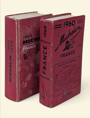 pair of red books sitting on top of each other in front of a white background