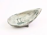 a small bowl with a boat on it on a white surface