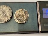 two coins sitting on a scale with a digital clock
