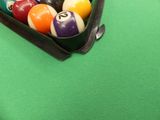 des boules de billard dans un étui noir posé sur un tapis vert