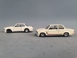 two toy cars sitting next to each other on a table