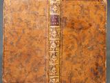 un vieux livre à la couverture brune et à la bordure dorée