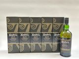 a bottle of ardbig whisky next to six boxes of whisky