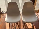 two white chairs sitting next to each other in front of a window